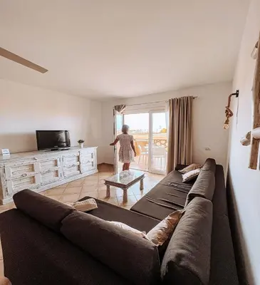 a woman standing in a living room with a couch at Sunset house Cabo Verde in Santa Maria