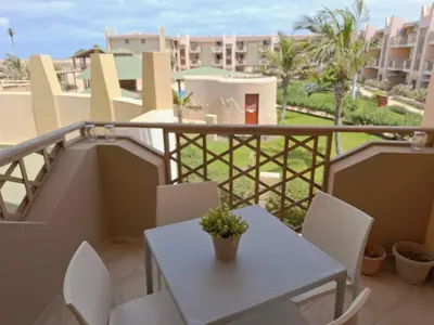 a balcony with a white table and chairs at Sunset house Cabo Verde in Santa Maria