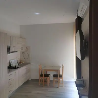 a kitchen with a table and chairs in a room at Ellen Apartamento T0 - Inforsal in Espargos