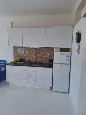 a kitchen with white cabinets and a refrigerator at Útulný apartmán na Praia de Chaves, Boa Vista in Sal Rei