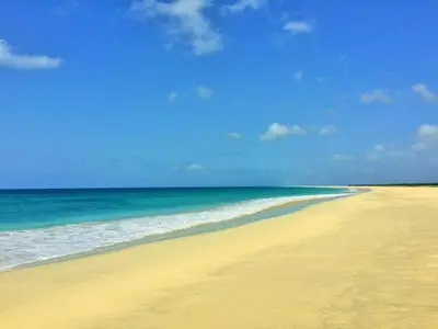 a beach with the ocean and a blue sky at Útulný apartmán na Praia de Chaves, Boa Vista in Sal Rei