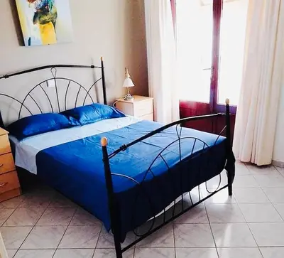 a bed with blue pillows in a bedroom at Vila Murdeira in Palha Verde