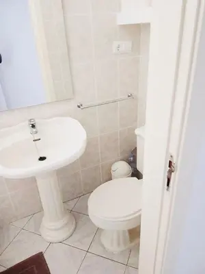 a white bathroom with a toilet and a sink at Vila Murdeira in Palha Verde