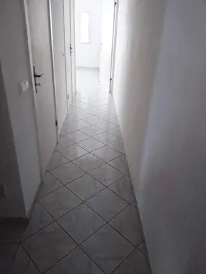 a hallway with white walls and a tiled floor at Vila Murdeira in Palha Verde
