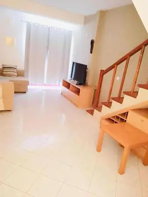 a living room with a staircase and a television at Vila Murdeira in Palha Verde