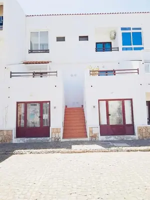 a white building with red doors and a red staircase at Vila Murdeira in Palha Verde