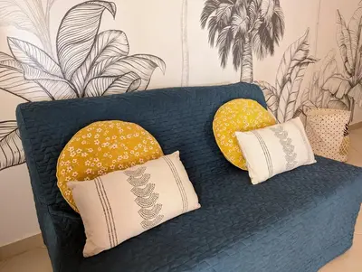 a blue couch with two yellow pillows on it at Tropical Leaves Sea view penthouse ca Greta 2 floor in Sal Rei