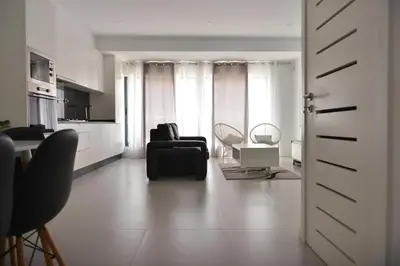 a living room with a black couch and chairs at Duarte Apartments - Lux in Mindelo