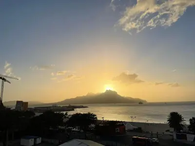 a sunset over a small island in the water at Duarte Apartments - Lux in Mindelo