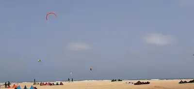 a group of people on a beach flying a kite at Atlantic Sal Hostel in Santa Maria