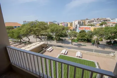 a balcony with chairs and a view of a street at Oasis Porto Grande in Mindelo