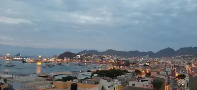 a city at night with boats in the water at Apartamento Fátima Amwilla Guesthouse in Mindelo