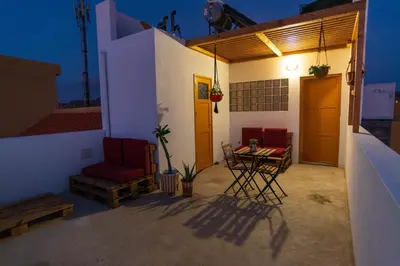 a patio with two chairs and a table on a house at Apartamento Augusta Amwilla Guesthouse in Mindelo