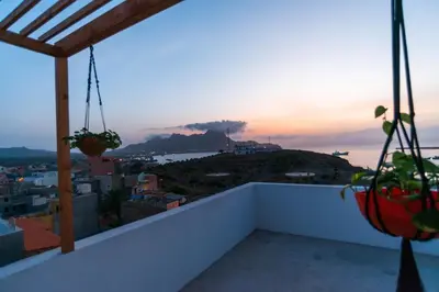 a balcony with a view of the ocean and a mountain at Amwilla Guesthouse Quarto WC privativo Elsa in Mindelo
