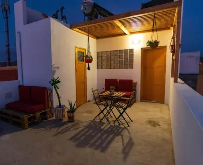 a patio with a table and chairs on a house at Amwilla Guesthouse Quarto WC privativo Elsa in Mindelo