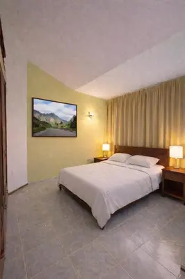 a bedroom with a large bed with two tables and two lamps at Casa BB&Djassi - SUITES in Ponta do Sol
