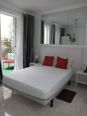 a white bed with two red pillows in a bedroom at Ana Place in Praia