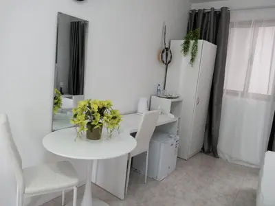 a white dining room with a white table and chairs at Ana Place in Praia