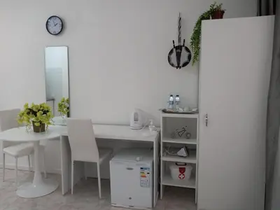a room with a white desk and a table and a mirror at Ana Place in Praia