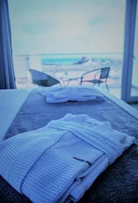 a bed with a towel on it with a view of the beach at DESIGN SUITES Boutique Hotel - Adults Only in Santa Maria