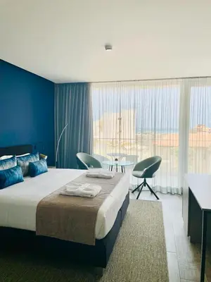 a bedroom with a large bed and a table and chairs at DESIGN SUITES Boutique Hotel - Adults Only in Santa Maria