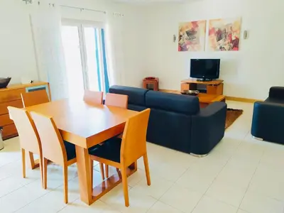 a living room with a table and a blue couch at Apartamento Privado Vila Verde in Santa Maria