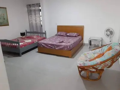 two beds and a chair in a room at Apartamento T1 Moderno com Wi-Fi in Praia