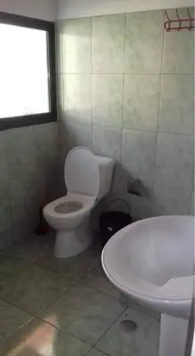 a bathroom with a white toilet and a sink at Apartamento T1 Mobilado com Wi-Fi in Praia