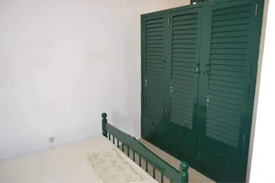 a green closet with a green door in a room at Apartamento T1 Mobilado com Wi-Fi in Praia