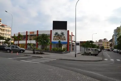 a parking lot with cars parked in front of a building at AP2B Praia in Praia