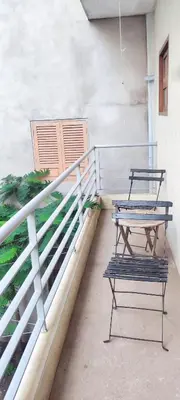two benches sitting on a porch with a table at casa verde lucas in Mindelo