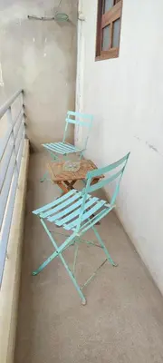 two blue chairs sitting next to a wall at casa verde lucas in Mindelo