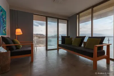 a living room with couches and windows with a view at Seafront Holiday House on the Mindelo Bay in Mindelo