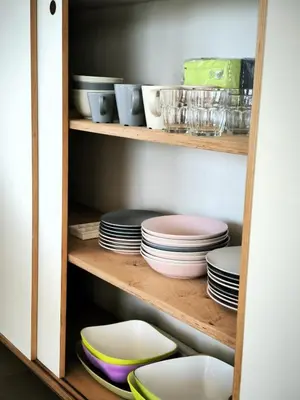 a cupboard filled with plates and bowls at Seafront Holiday House on the Mindelo Bay in Mindelo