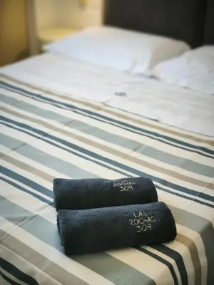 a black towel is sitting on a bed at Seafront Holiday House on the Mindelo Bay in Mindelo
