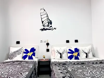 two beds in a room with blue and white at ANIMOSS! APARTMENTS - 10 modern apartments near city center & beach in Santa Maria