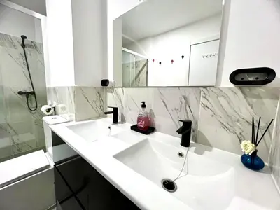 a white bathroom with a sink and a mirror at ANIMOSS! APARTMENTS - 10 modern apartments near city center & beach in Santa Maria