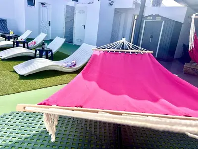 a pink hammock in a room with chairs at ANIMOSS! APARTMENTS - 10 modern apartments near city center & beach in Santa Maria