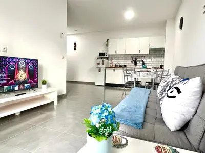 a living room with a couch and a kitchen at ANIMOSS! APARTMENTS - 10 modern apartments near city center & beach in Santa Maria