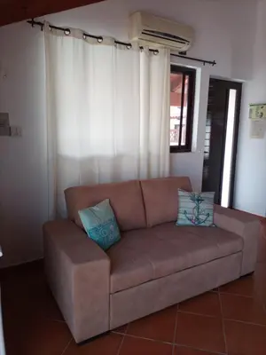a brown couch with two pillows sitting in a living room at Porto Antigo 2 Apt 72 TOP FLOOR WITH SEA VIEW in Santa Maria