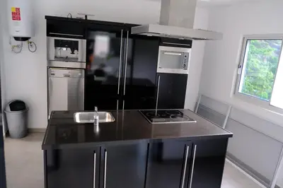 a kitchen with a black counter top and a stove at VILLA NAYELI Luxury and Simplicity in Órgãos