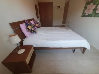 a bedroom with a bed and a table with a lamp at Appartement Amalia Sal Santa Maria in Prainha