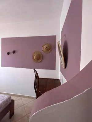 a room with purple walls and a table and a chair at Casa Carlotta - Authentic Stay in Maio in Vila do Maio