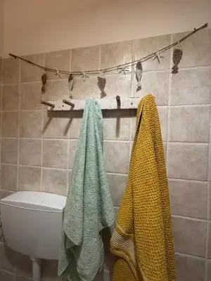 a bathroom with a toilet and towels on a shelf at Casa Carlotta - Authentic Stay in Maio in Vila do Maio