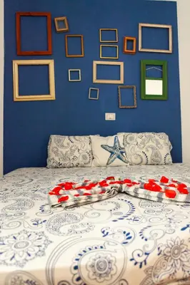 a bed with a blue wall with pictures on it at Casa Carlotta - Authentic Stay in Maio in Vila do Maio