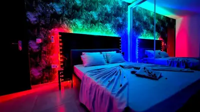 a bedroom with a large bed with pink and blue lights at Appartement Cara do Mar in Praia