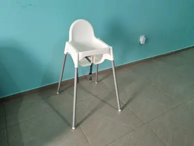 a white chair sitting in front of a blue wall at Appartement Cara do Mar in Praia