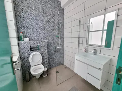 a bathroom with a toilet and a sink and a shower at Appartement Cara do Mar in Praia