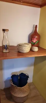 a shelf with three vases and baskets on it at Kasa d'Vizin in Paul