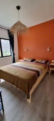 a bedroom with a bed with an orange wall at Kasa d'Vizin in Paul